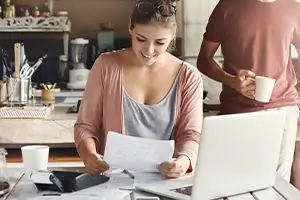 Mulher analisando fatura em casa, ilustrando contratação de serviços da Desktop